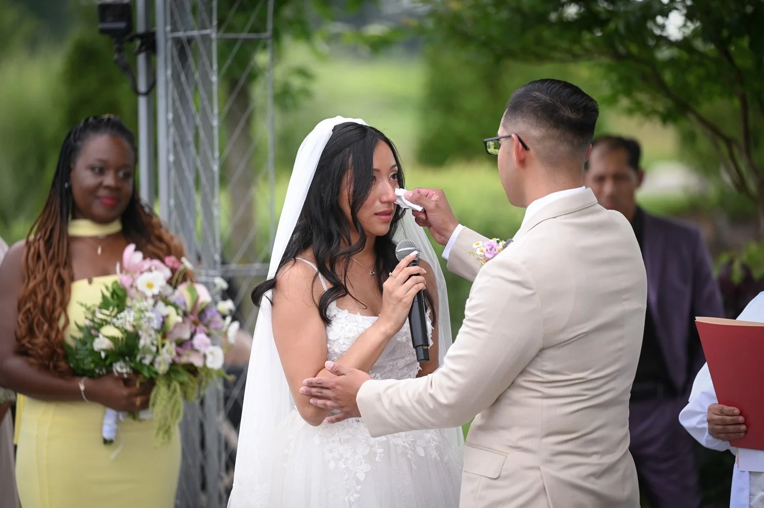 during the ceremony the groom wipes a tear from the brides face
