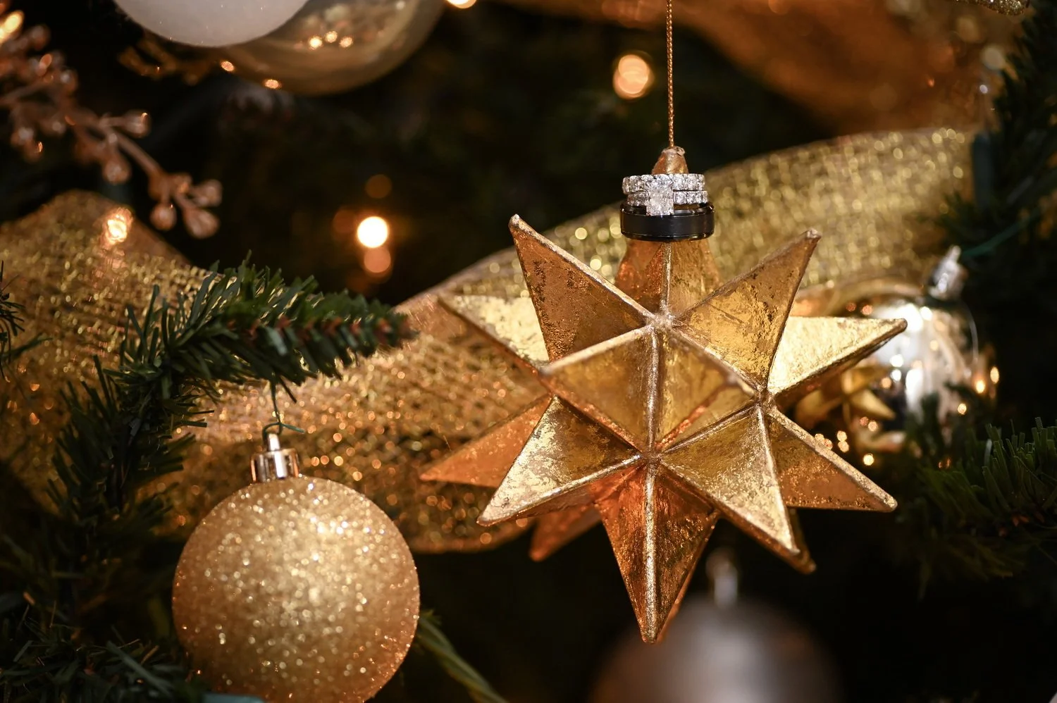 bride and grooms wedding rings hanging on an ornament on Christmas tree at Deerfield