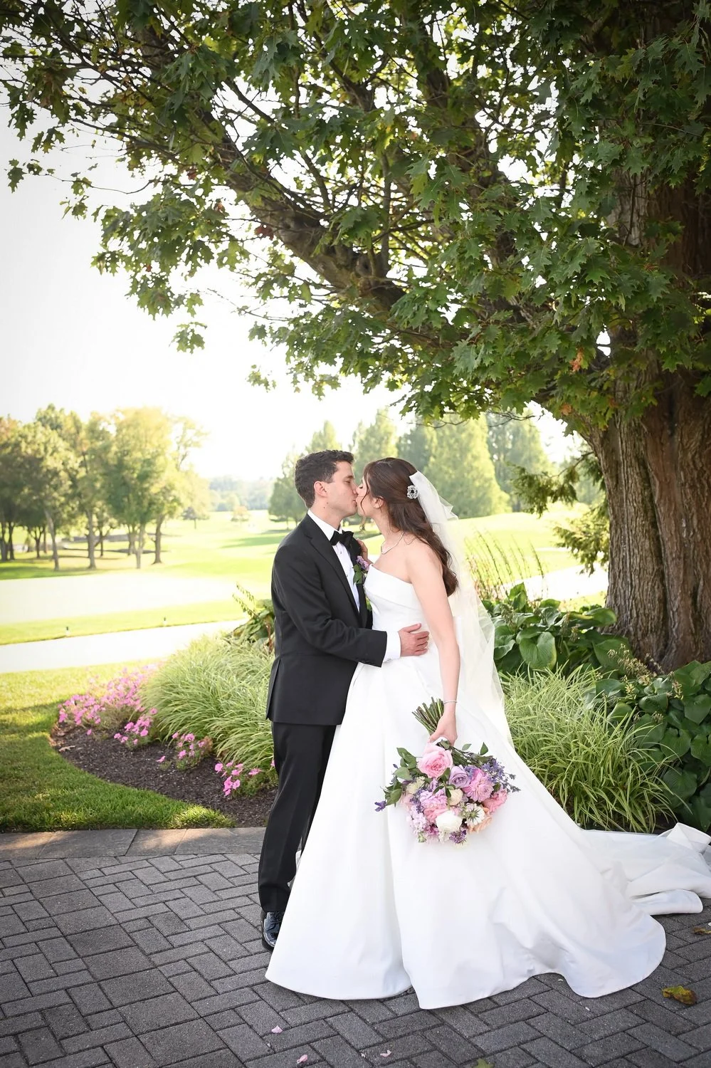 bride and groom kissing on patio at wilmington country club on their wedding day