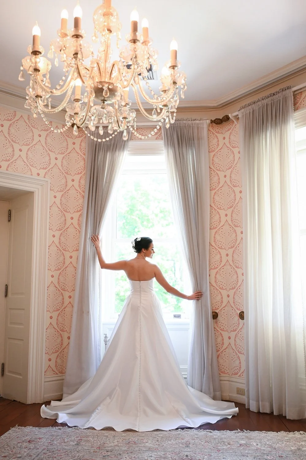 Bella in her wedding dress in getting ready room window at Bellevue Hall