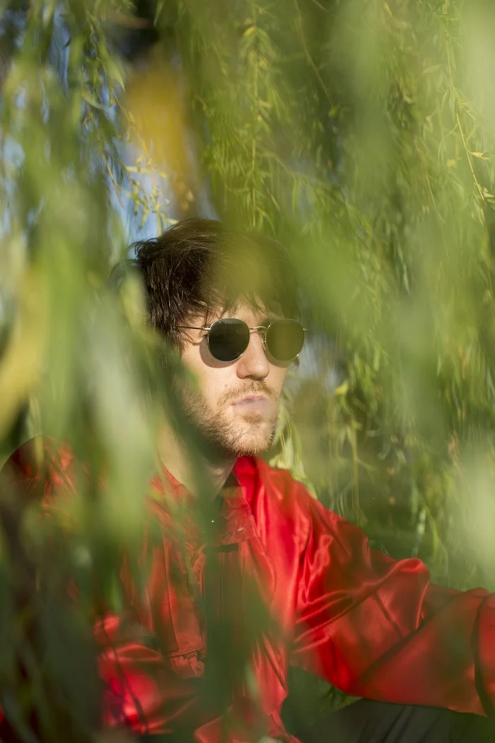 Bad Cop's Adam M. exhales amid the lush green foliage; photographed by Sam Saideman.
