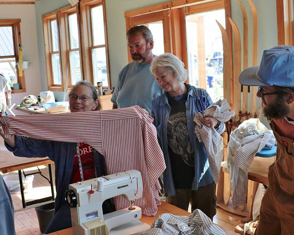 SS Carol demonstrating sewing work shirt.png