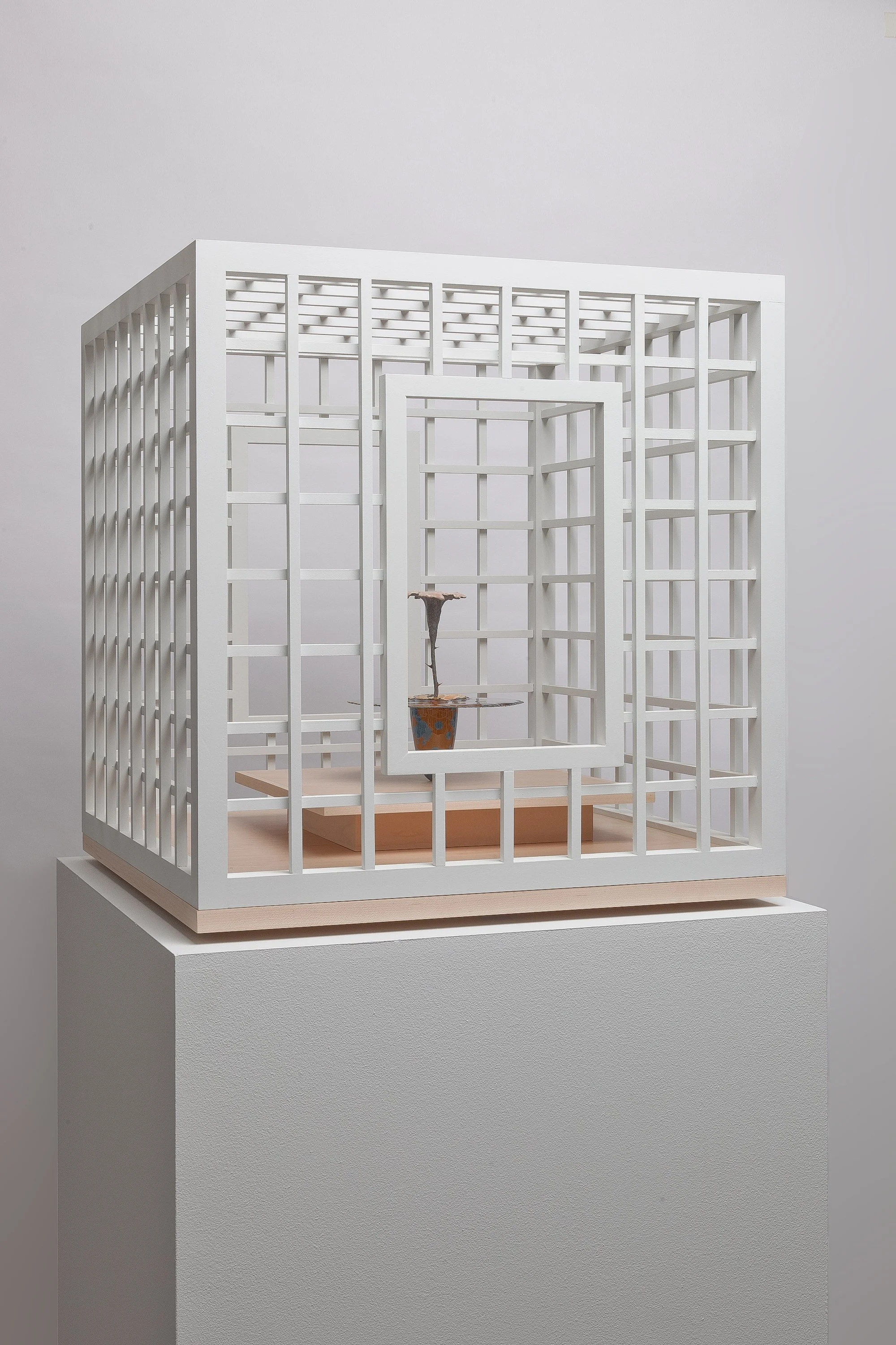 Obelisk (Eternal Bloom), 2024.   cremated leaves, rare earth elements, ceramic, twig,resin, steel, acrylic, maple.    Vitrine: 21.75”x21.75”x23”  Obelisk: 7”x8