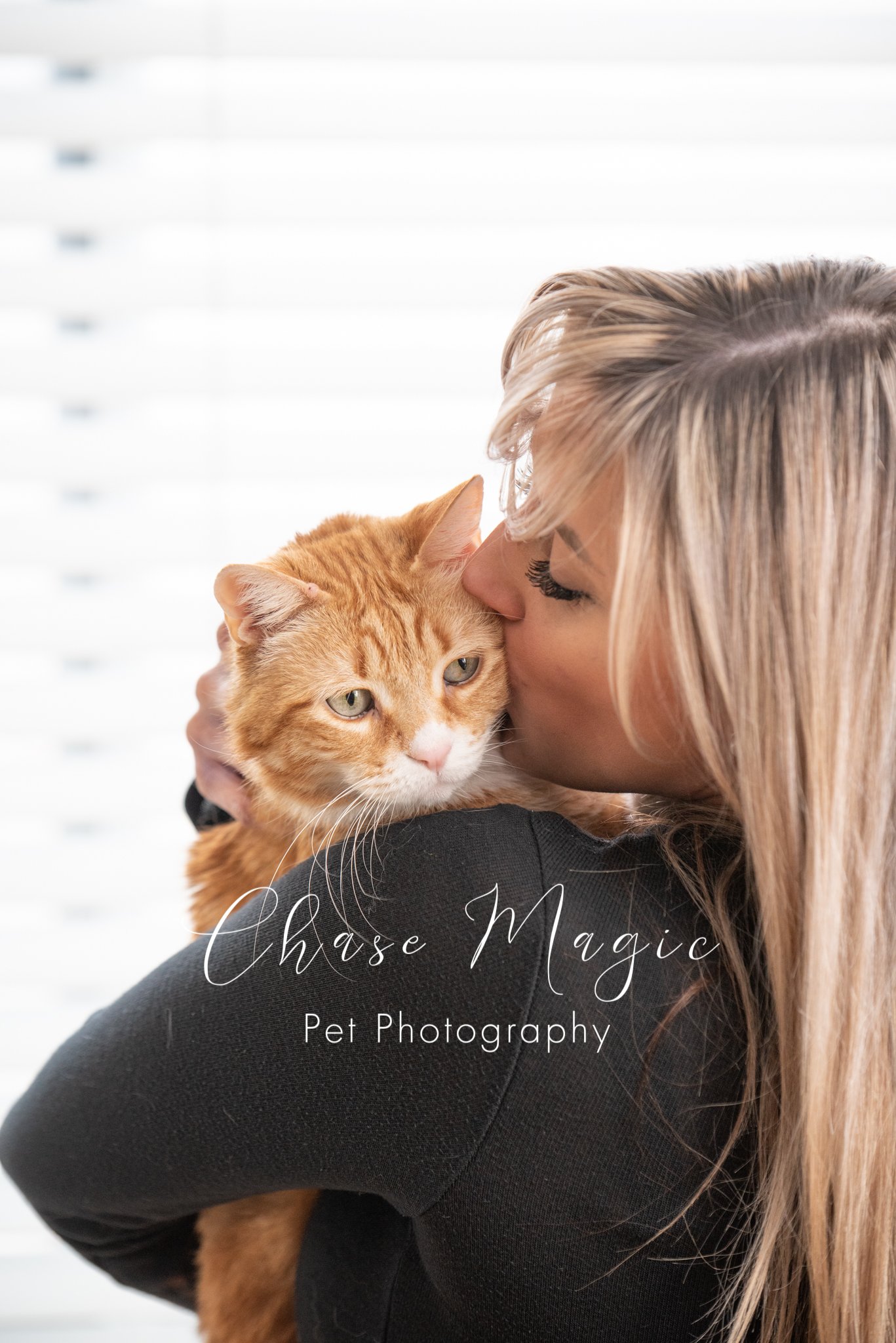 orange cat being held by a women and given a kiss