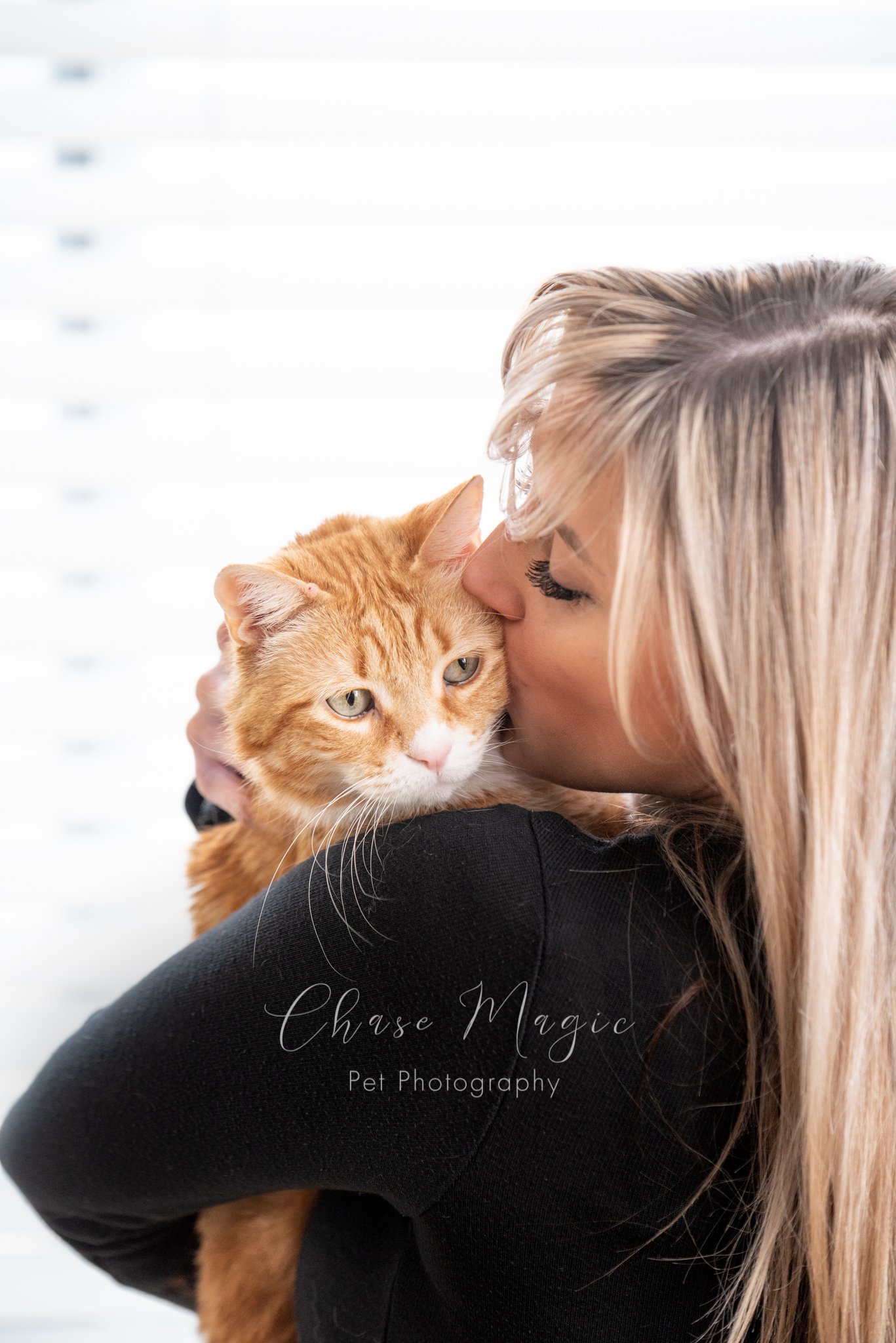 women hugging and kissing her orange cat