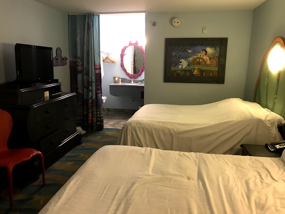 View of a Little Mermaid Standard Room. Pro Tip: There's a refrigerator in the shelving unit under the TV!