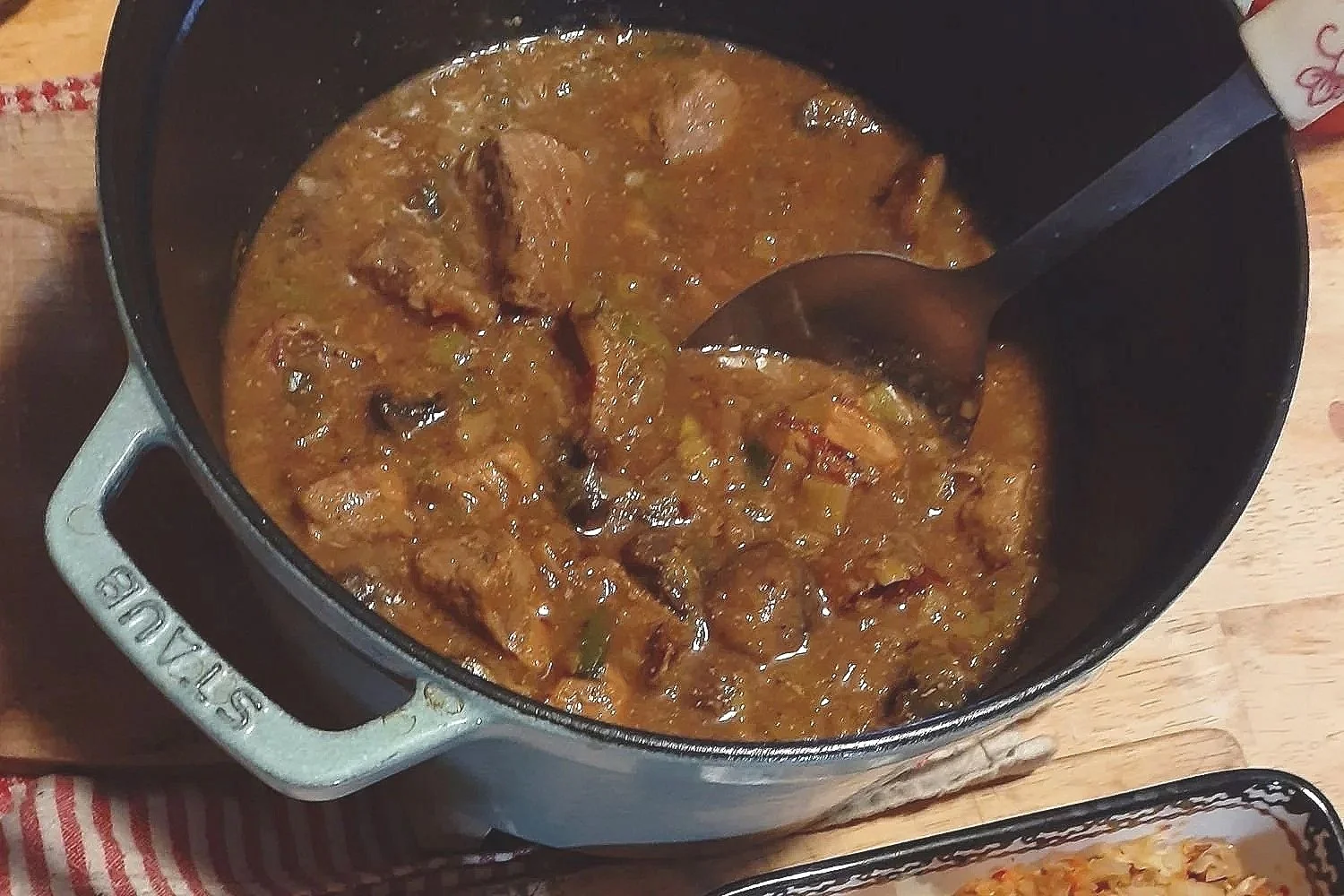 Cider-braised Berkshire pork stew with sautéed leeks and mushrooms in a rustic farmhouse kitchen.
