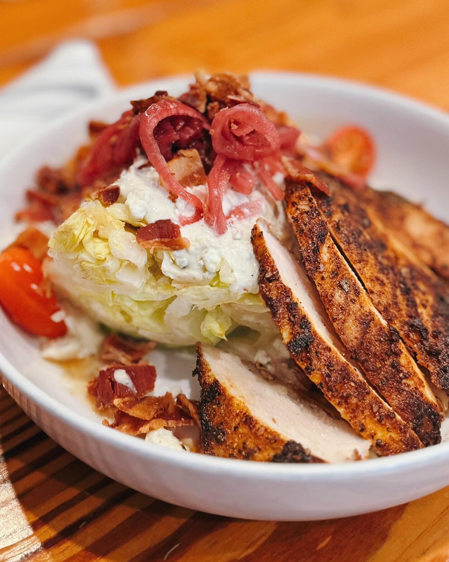 Enjoy a Wedge Salad with Blackened Chicken! &bull; Iceberg Lettuce with Housemade Blue Cheese Dressing, Pecan-Smoked Bacon, Blue Cheese Crumbles, Pickled Onions &amp; Cherry Tomatoes! 🍽️ Open 11AM to 9PM