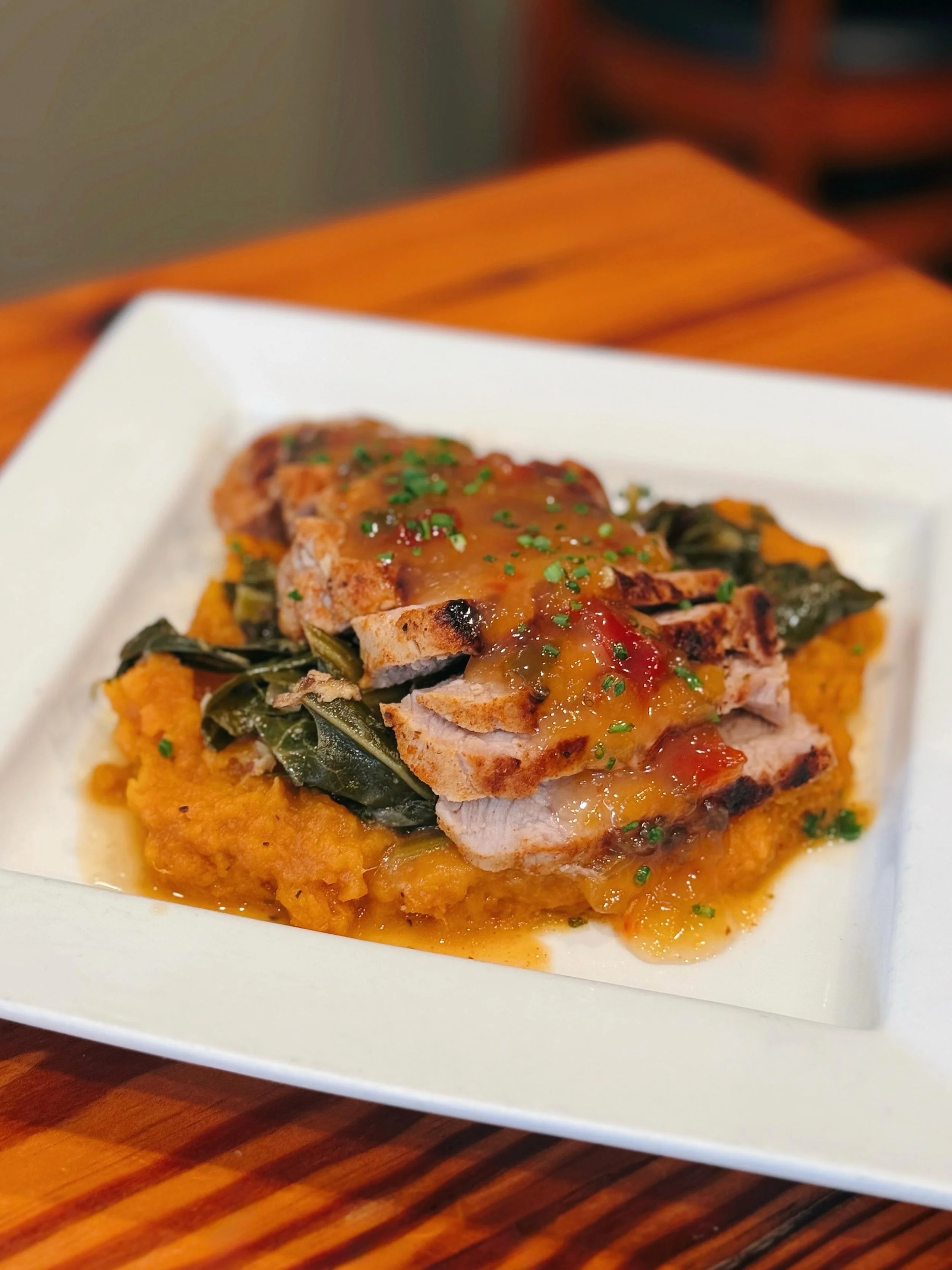 One of Our New Dinner Entr&eacute;es &bull; Orange &amp; Rosemary Brined Sliced Boneless Pork Tenderloin over Steen&rsquo;s Mashed Sweet Potatoes &amp; Braised Collards with Bacon and Topped with Peach Pepper Jelly! 🍽️ Available for Dinner Service O