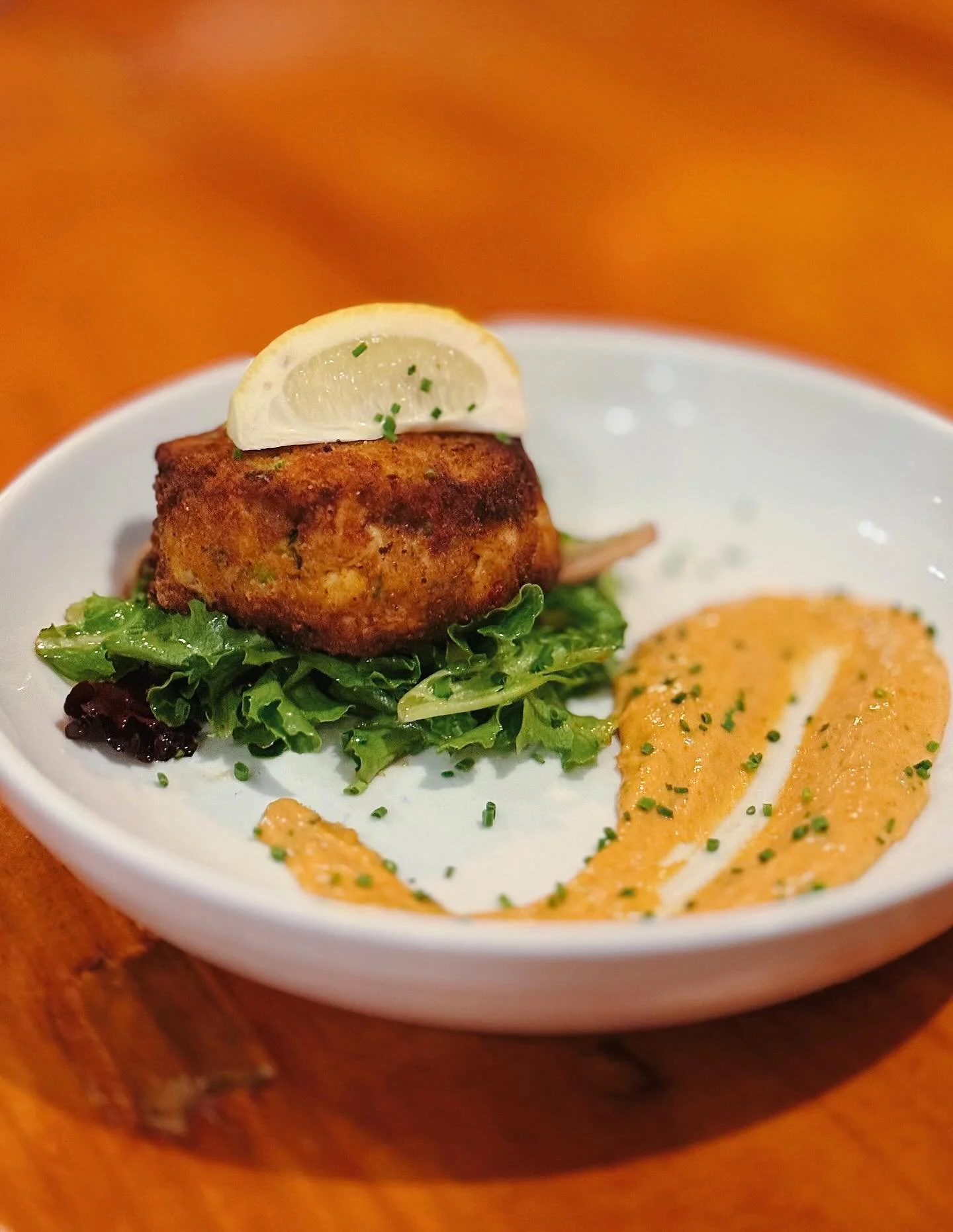 Dine with Us &amp; Enjoy a Crab Cake! 🦀 Served over Mixed Greens in a Pepper Jelly Vinaigrette with Remoulade Sauce 🍽️ Open 11AM to 9PM!