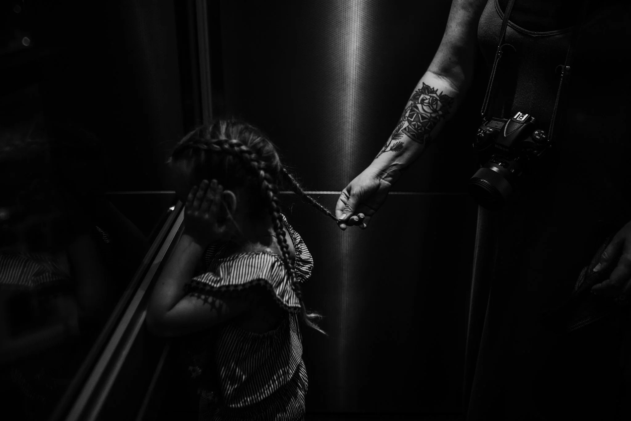 Mother plays with daughter's hair in elevator