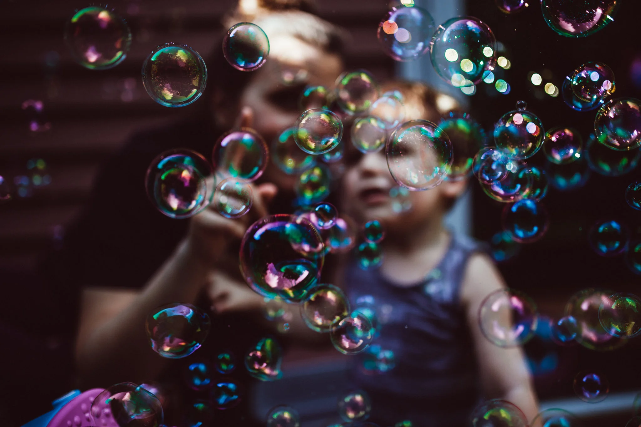 Mom and toddler behind a wall of bubbles