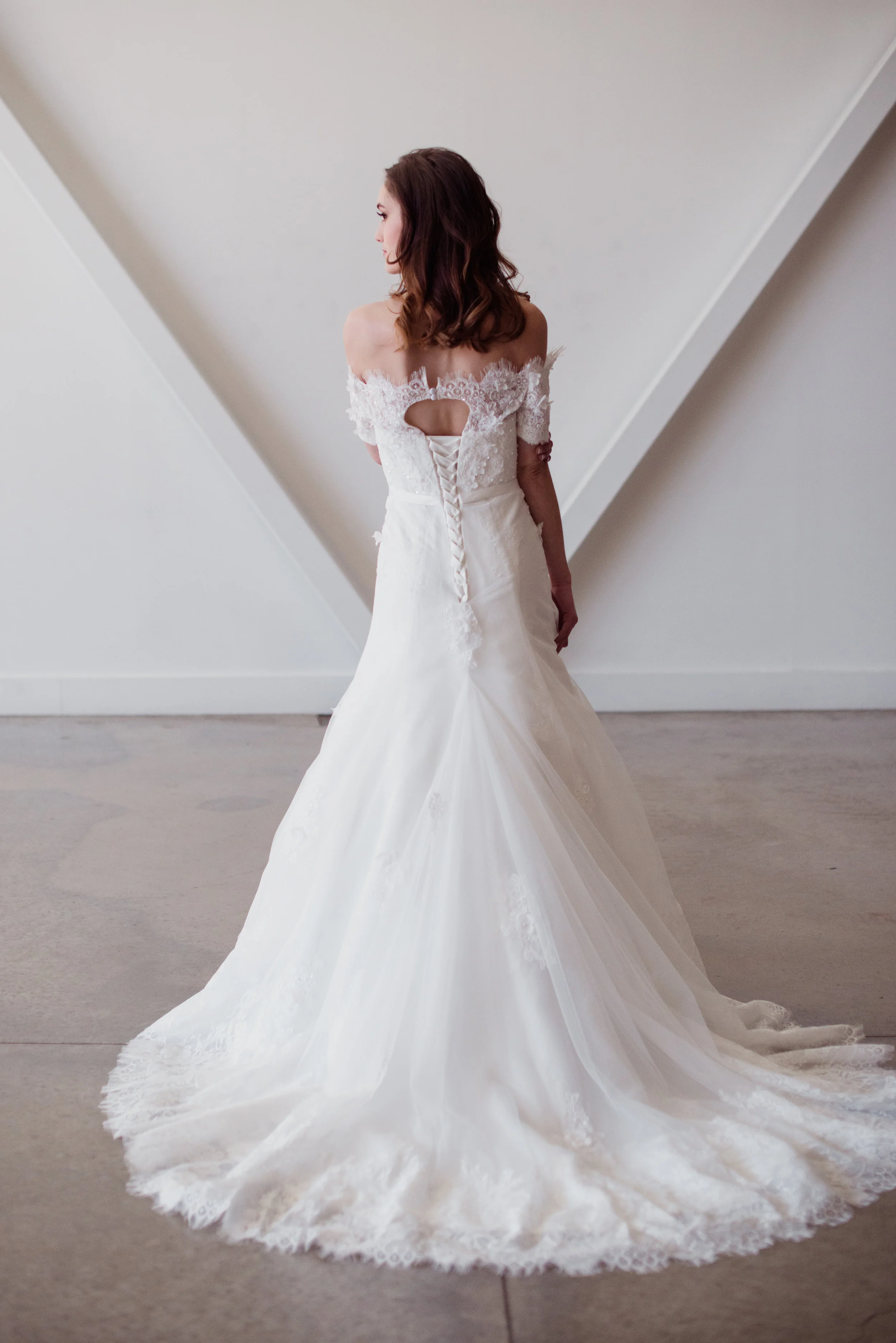 Juliet gown simple wedding gown by Lyra Vega Bridal with off the shoulder lace details and small keyhole back and chapel train