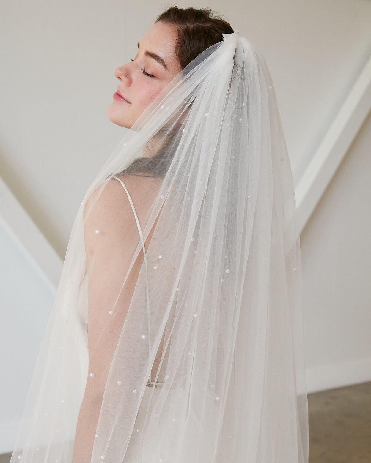 The only thing better than a pearl veil is a pearl veil with sleeves! This soft tulle veil is bringing all of the drama, from its balloon sleeves to its scattered pearl embellishments. This modern accessory is a fun addition to any wedding gown and a