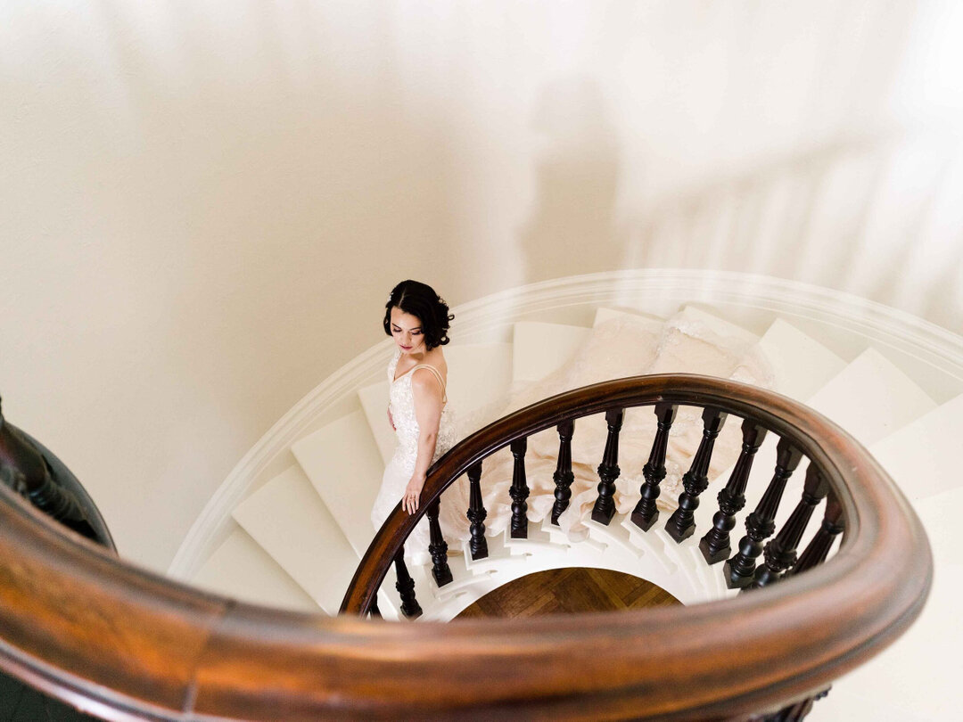 What is a grand entrance without a spiral staircase? Our Thea gown was made for a sweeping entrance like this with its chapel train and crystal-traced lace. Surely to catch the light as you make your descent down the stairs (or the aisle), this gown 