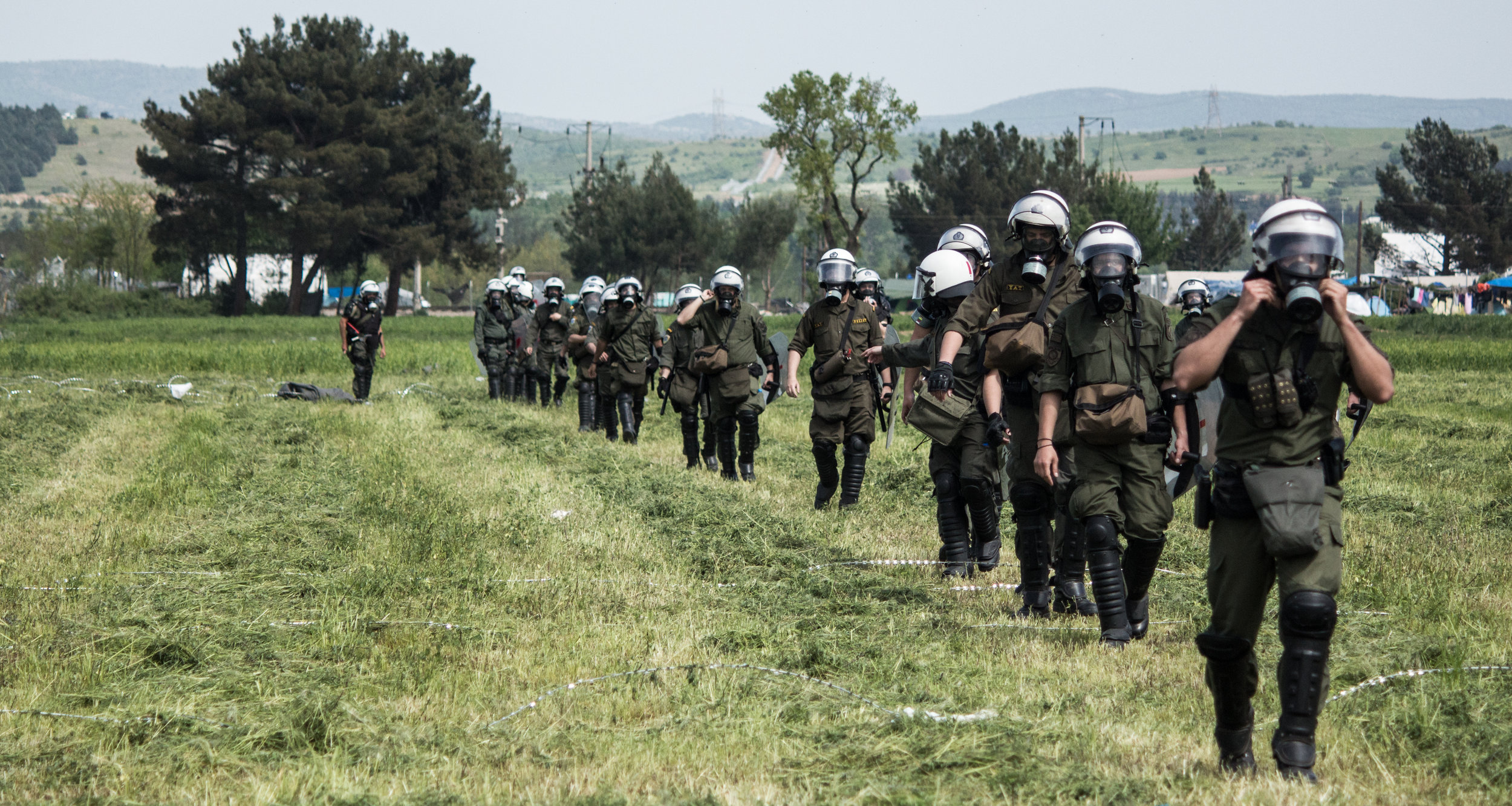 A Greek riot police unit approaches the Greek-FYROM border in Idomeni during clashes in April 2016. There was very heavy military and police presence in attempted push backs to keep the border fences intact.