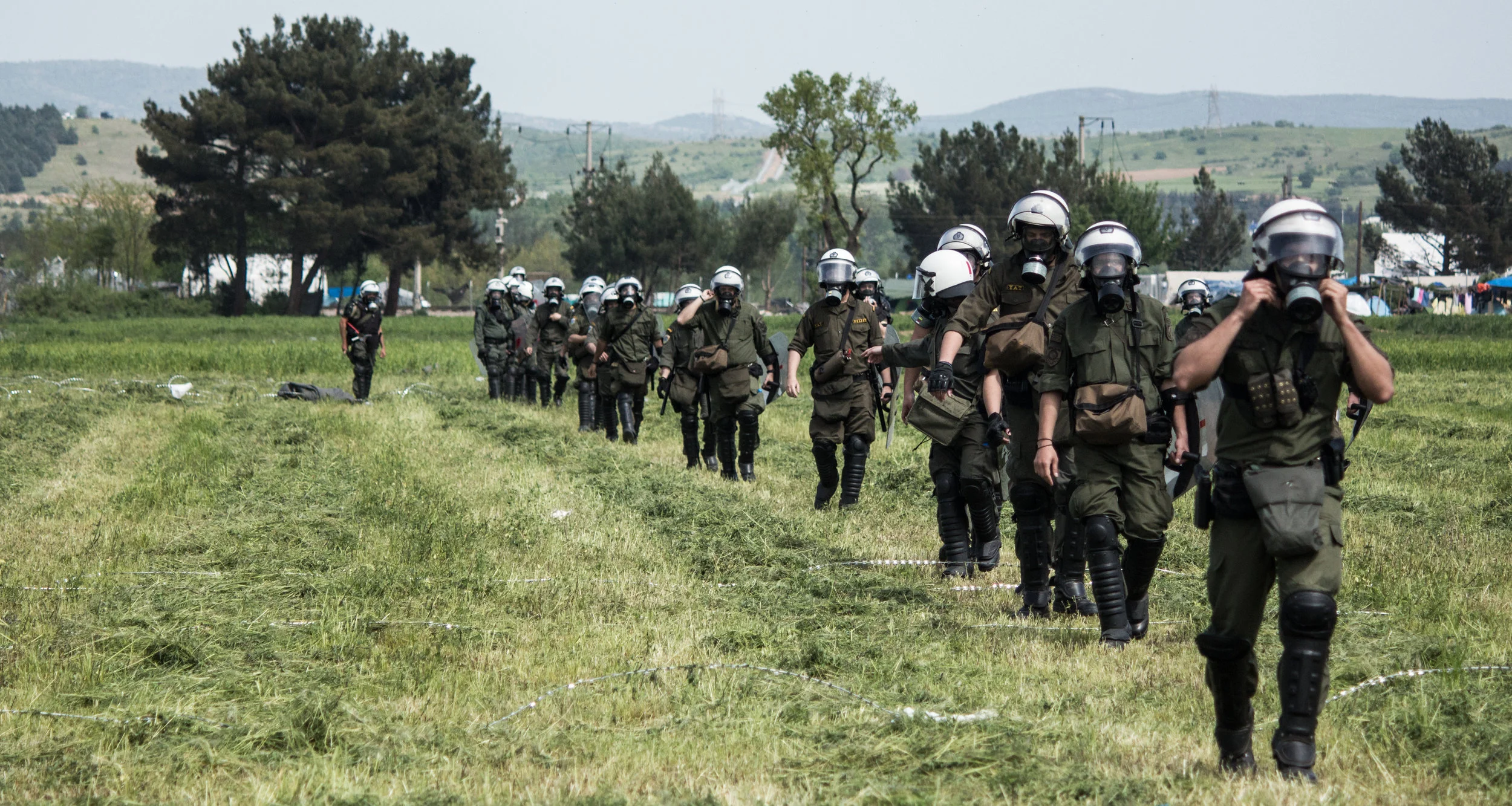 A Greek riot police unit approaches the Greek-FYROM border in Idomeni during clashes in April 2016. There was very heavy military and police presence in attempted push backs to keep the border fences intact.