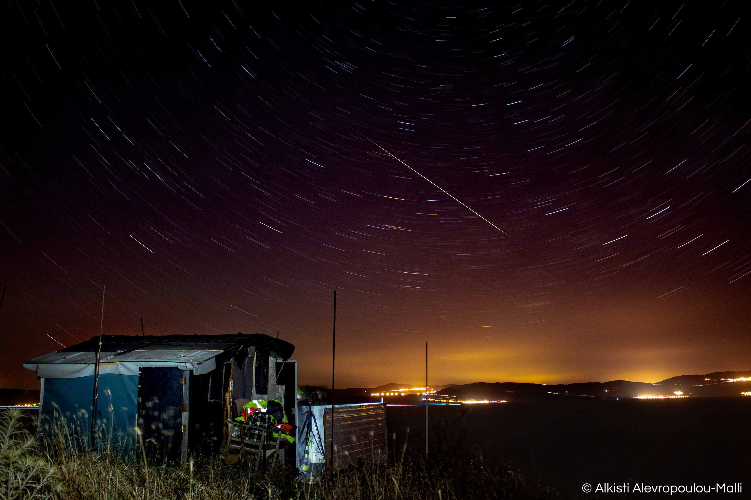 A shooting star falls above the infamous spotting hut in Korakas. This hut was built by volunteers in 2015 out of need, and has been used as a shelter for volunteers during night-spotting shifts ever since.