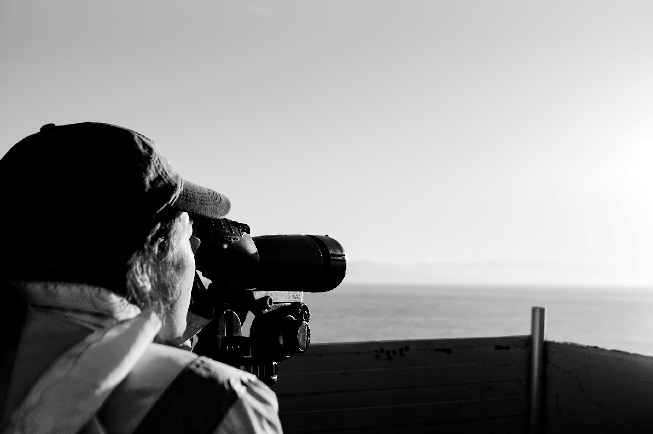 A volunteer scans the horizon with a telescope, looking for possible migrant boats crossing to Greece from Turkey.