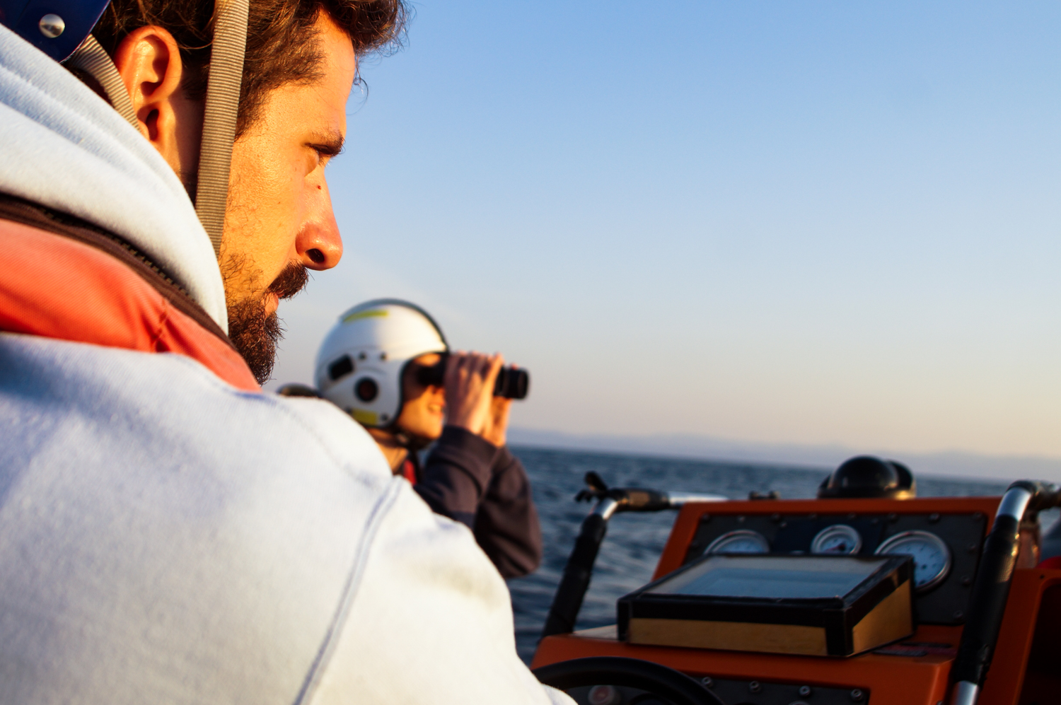 Search and Rescue boat crew scans the horizon for the exact location of a suspected migrant vessel.