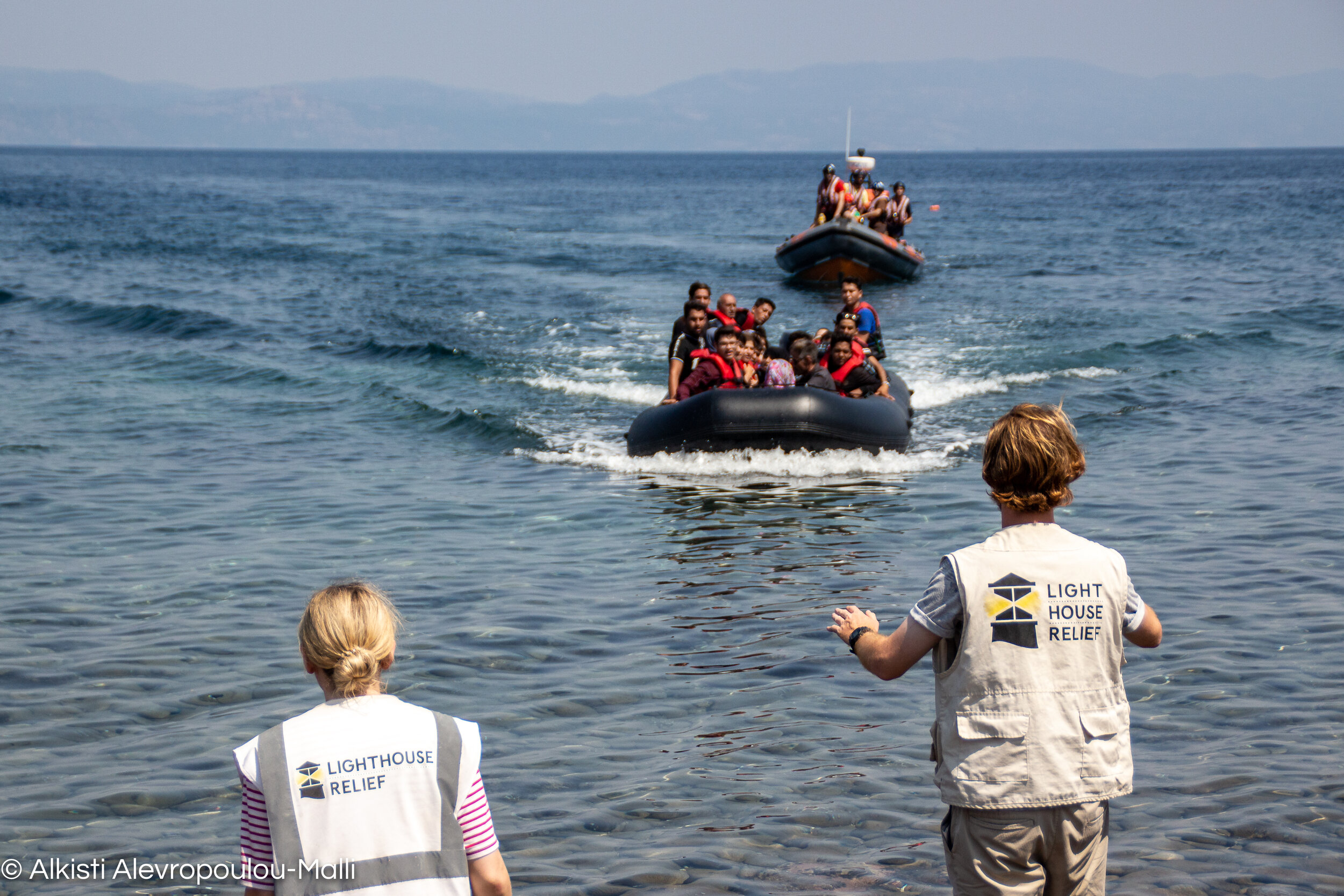 A dinghy full of migrants approaches the shore, followed closely by the Search and Rescue boat MoChara of Refugee Rescue.