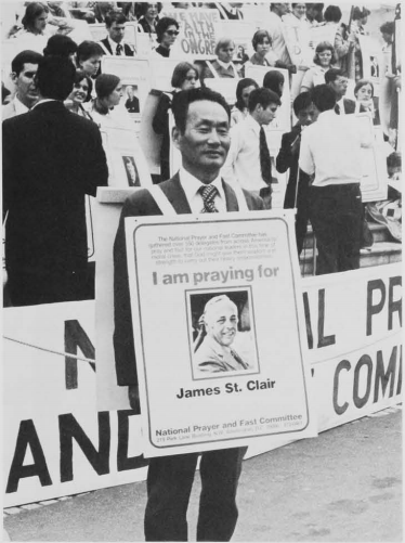 David S.C. Kim wears placard for attorney James St. Clair