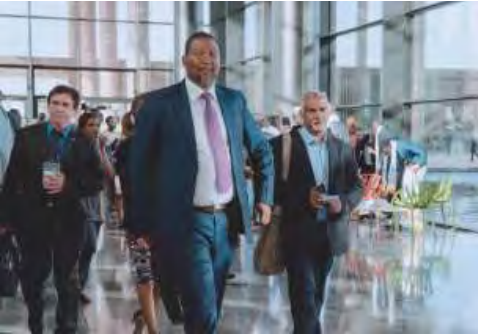 Patrick Jouan (left) walking at the Abdou Diouf International Conference Center