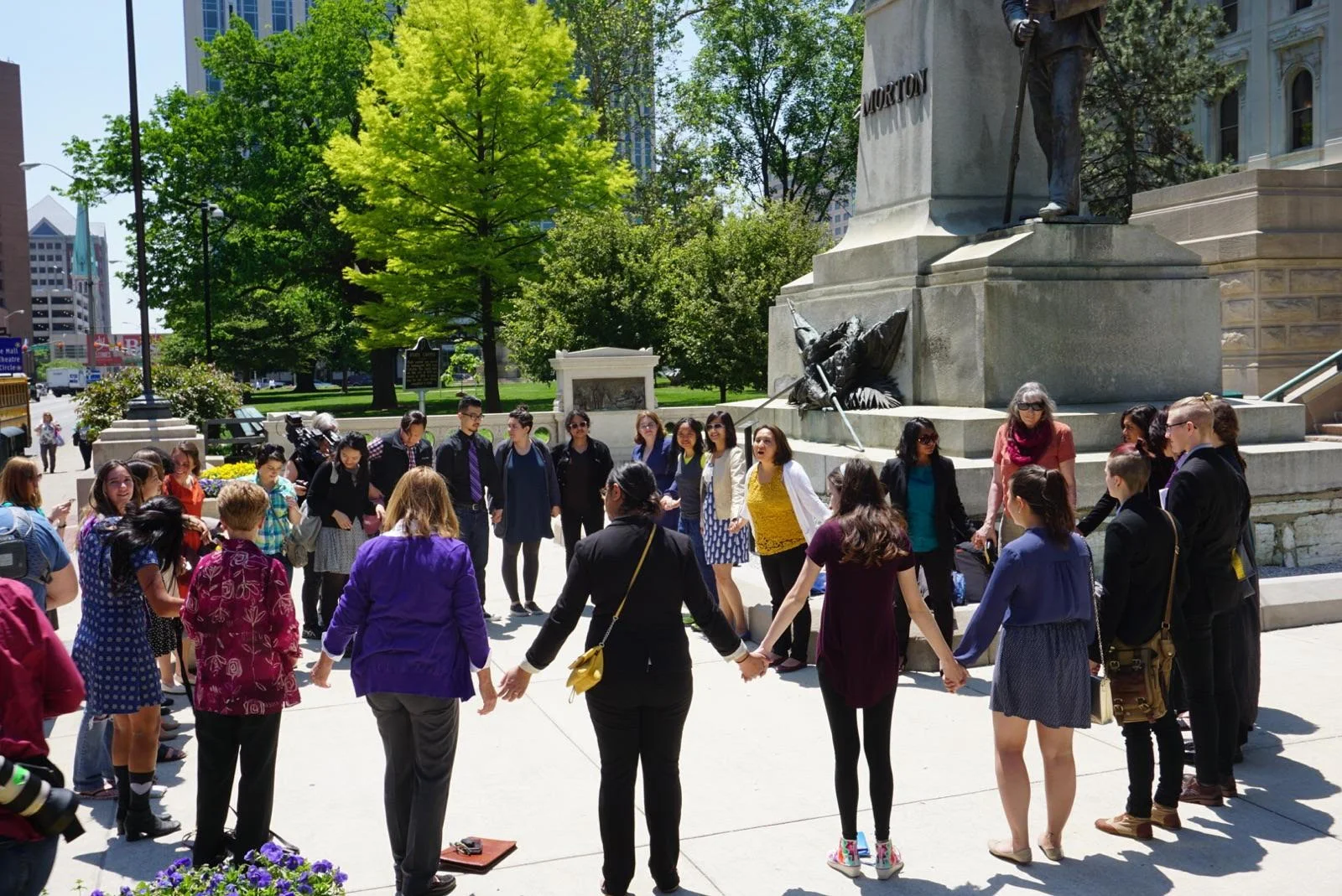 A circle of activists hold hands in front of the Indiana State Capitol to show solidarity with Purvi Patel.