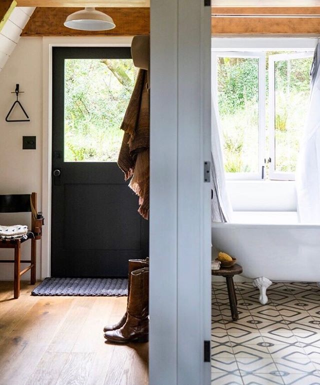 both the mud room + bathtub look out onto the back deck surrounded by wild huckleberry, ferns, coffee berry + bay trees 🌿💚.. I love that my ever present boots + my grandfather&rsquo;s binoculars are in this photo by Tom Story @sunsetphoto .. design