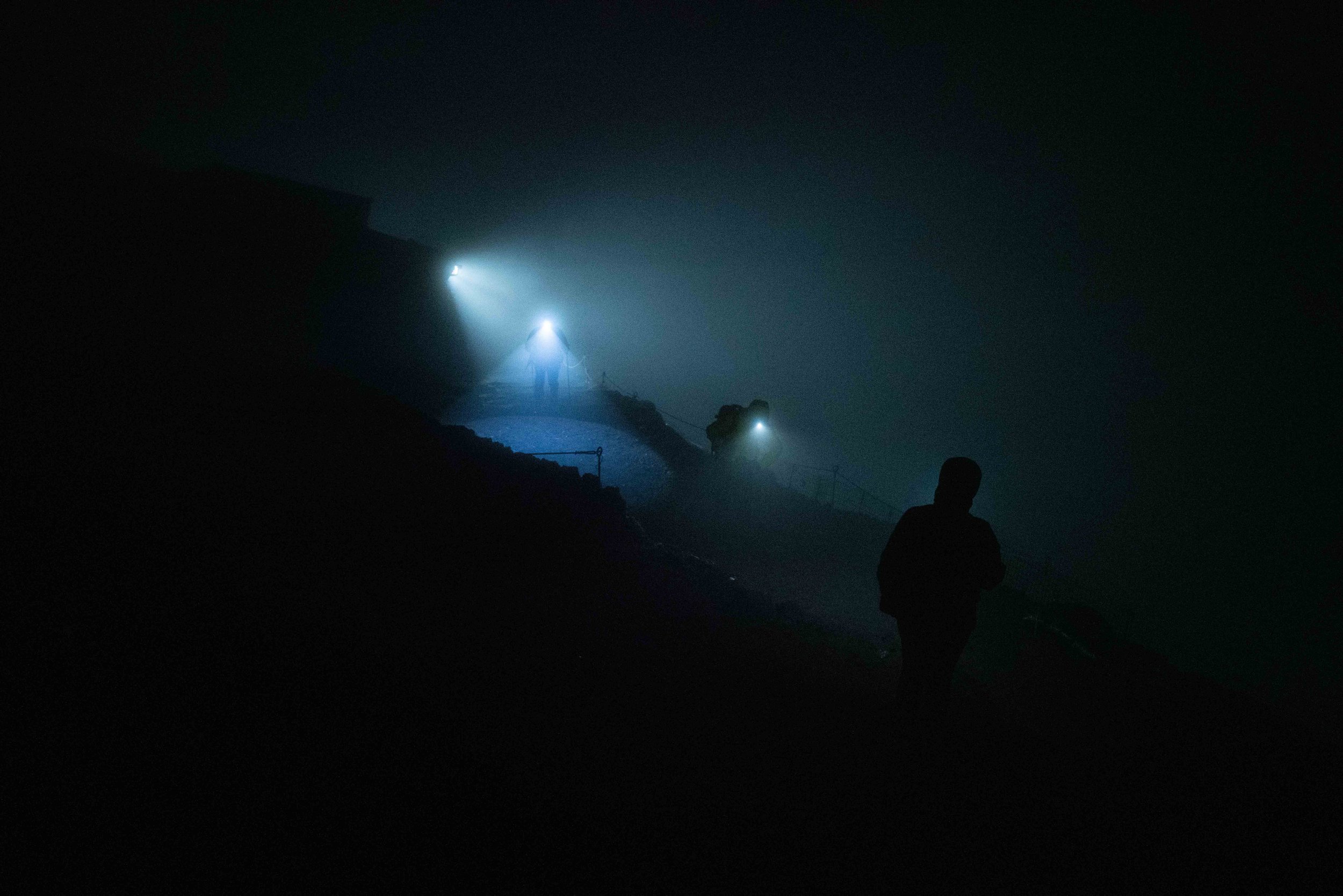 Hikers in the early morning struggling to see the Yoshida trail in the thick fog