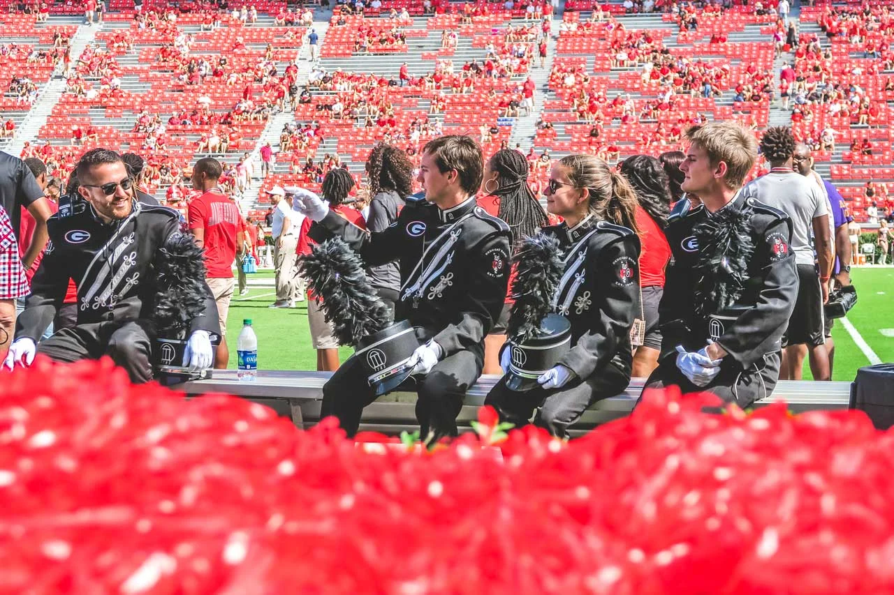 Three members of the Redcoats relax during pregame of UGA vs MTSU