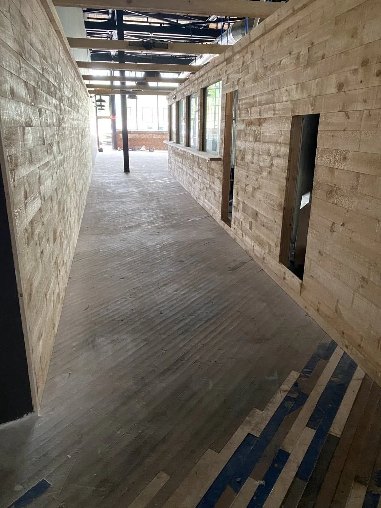Corridor floor before refinishing, worn and paint-marked, in a Norwalk, CT warehouse