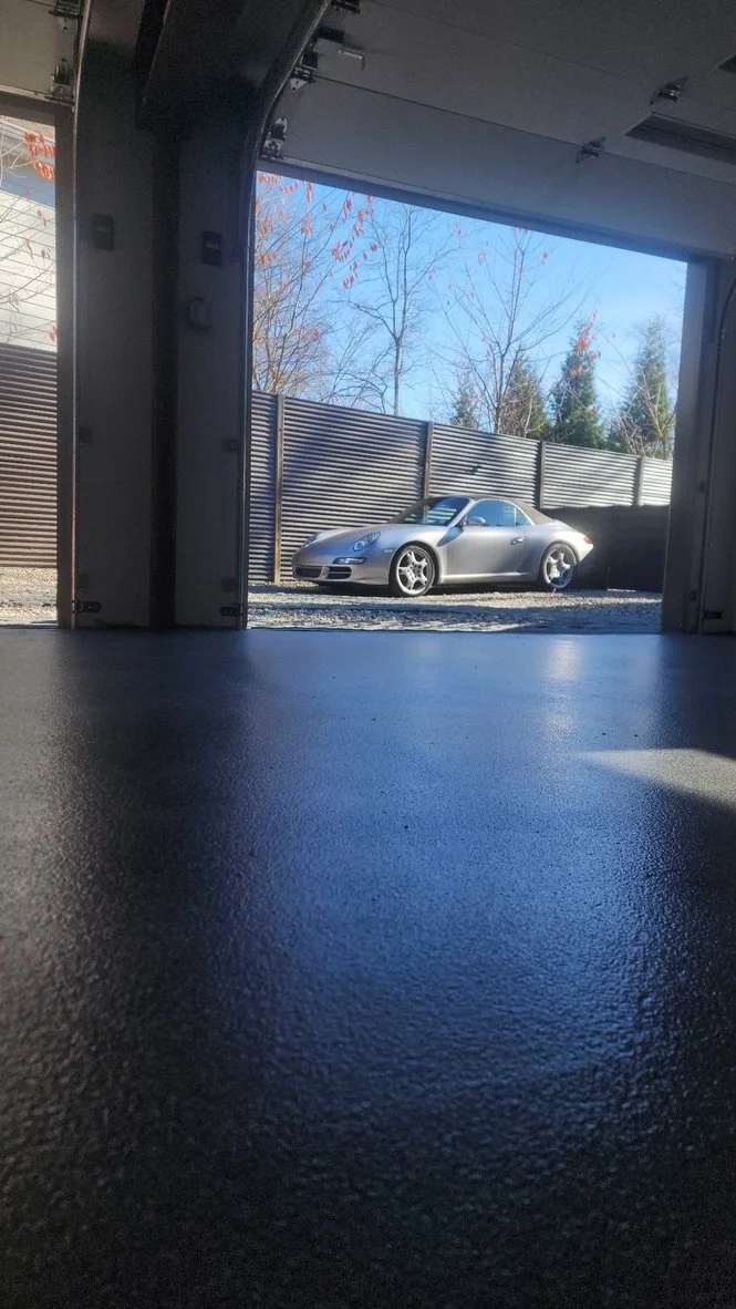 Finished epoxy garage floor with a car parked just outside the open garage door, Trumbull, CT