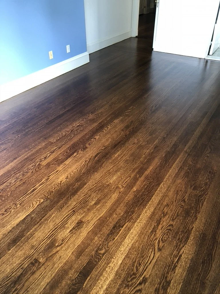 Random-width oak boards with old nail heads after refinishing in a paneled room, Stamford, CT