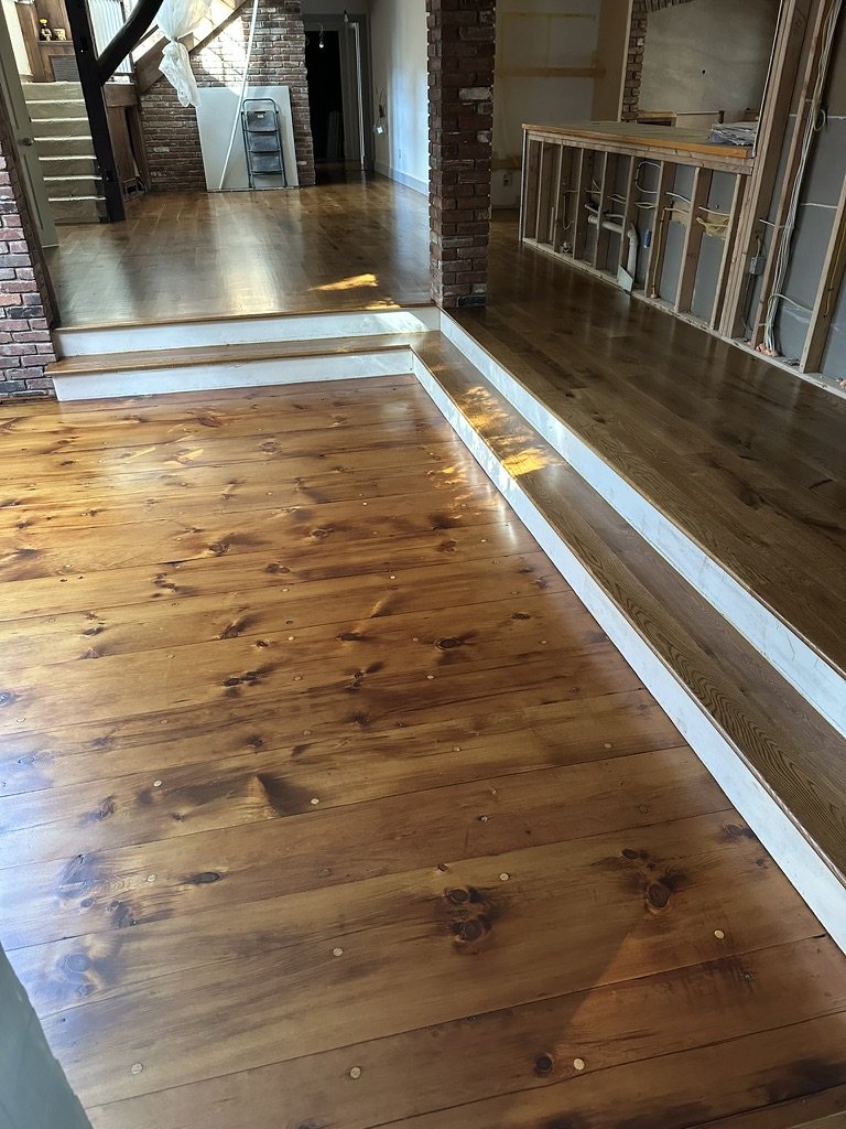 Wide-plank oak floor transitioning into a closet nook during installation in a Weston, CT home
