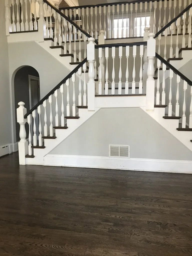 Dark-stained red oak floor in a double-staircase hall after refinishing, Fairfield, CT