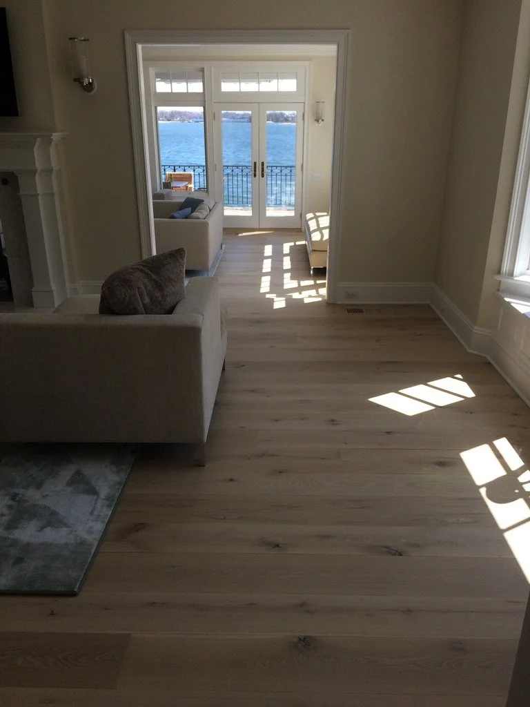 Wide-plank white oak hardwood floor in an empty Stamford, CT room, showing the transition to an adjoining space