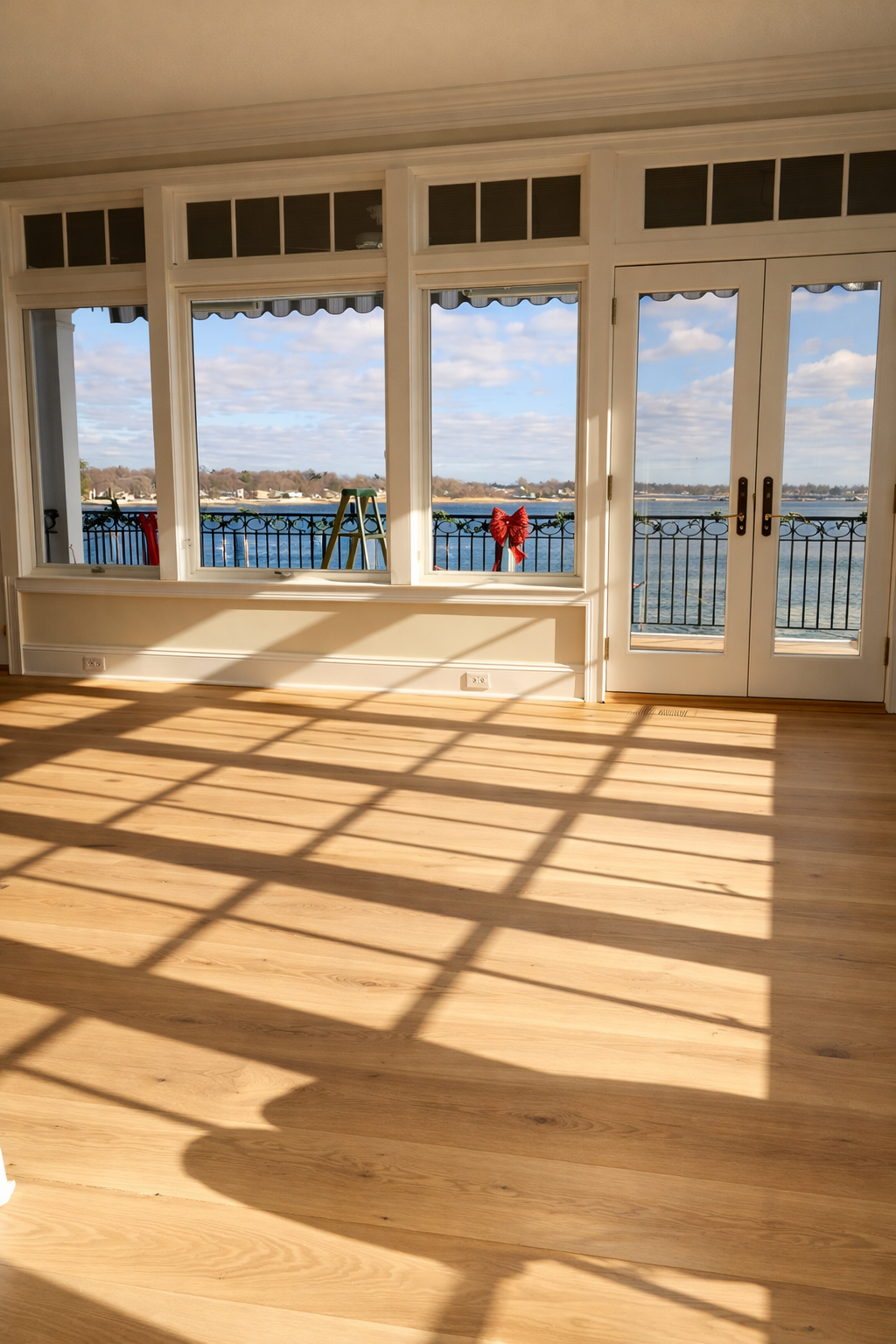 Newly installed white oak hardwood floor in an unfurnished Stamford, CT room overlooking the water
