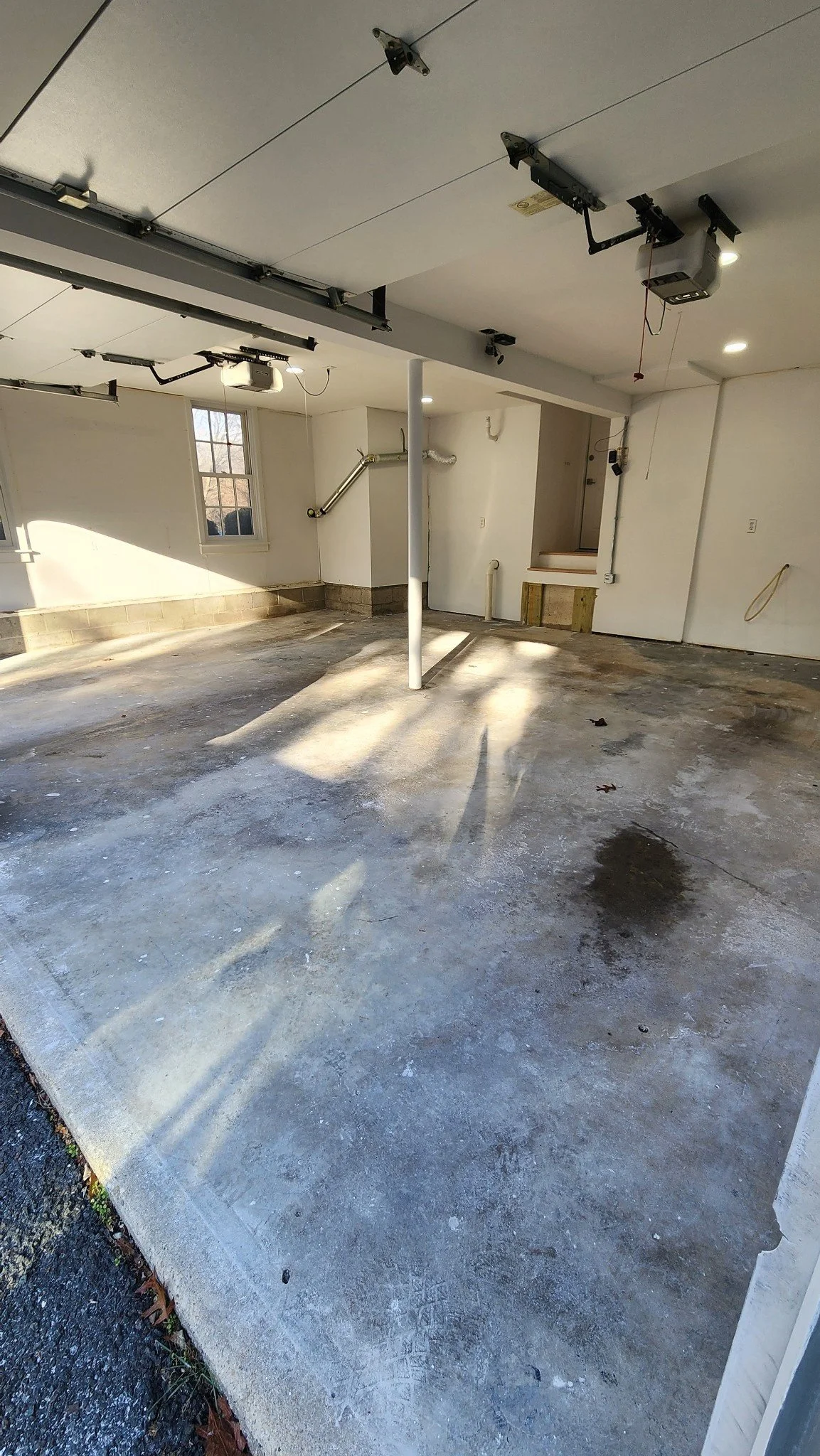 Diamond grinder equipment prepping a stained concrete garage floor before epoxy coating, Weston, CT