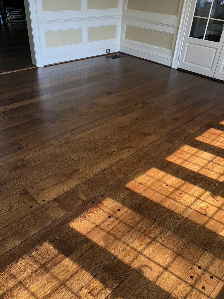 Refinished wide-plank oak floor in a sunlit dining room with leaded-glass windows, Stamford, CT