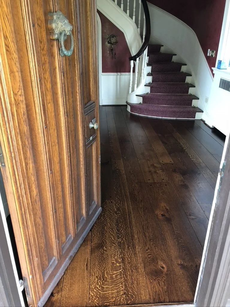 Refinished random-width oak floor with a dark stain in a Shippan Point foyer, Stamford, CT