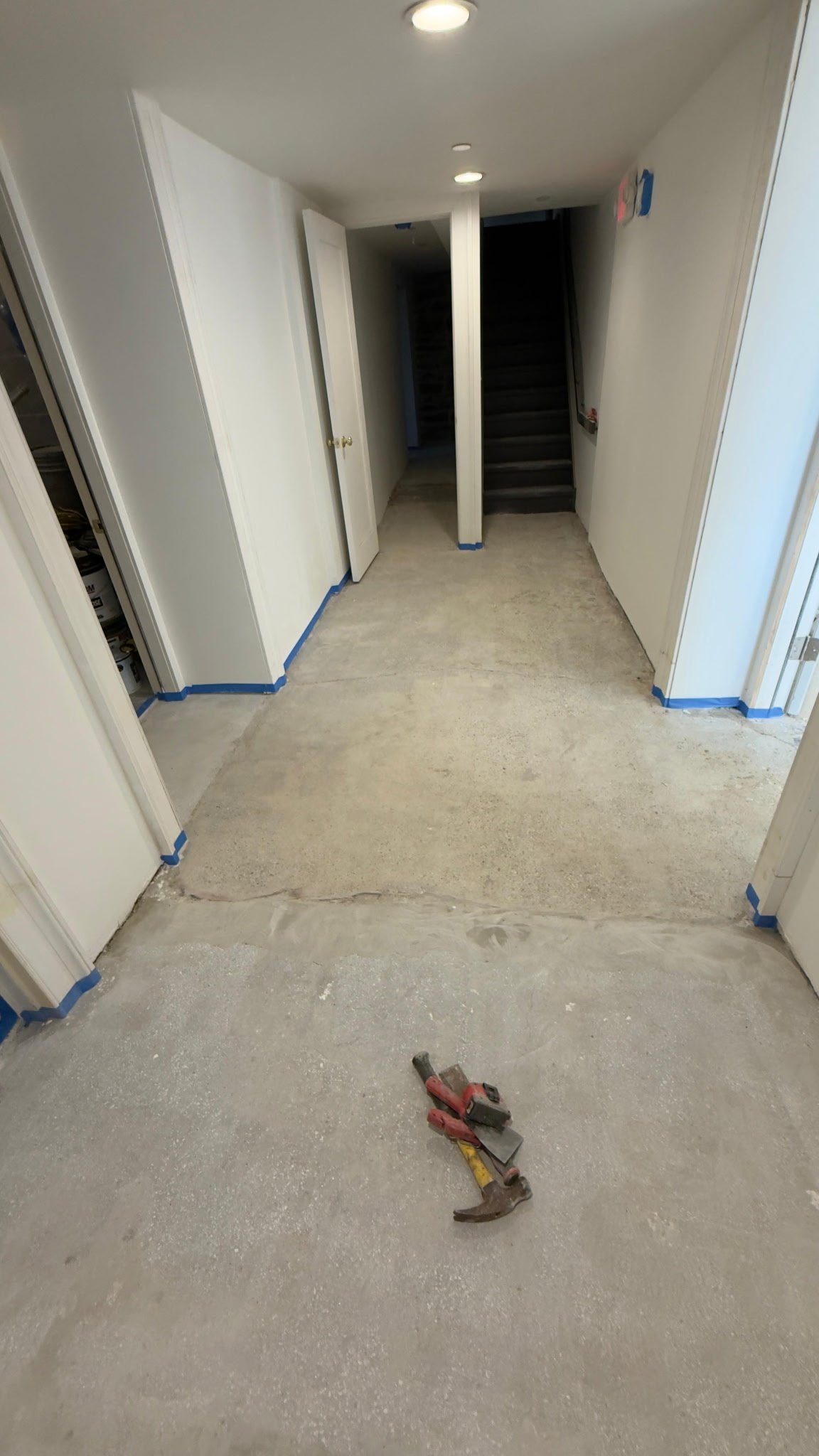 Bare concrete basement corridor viewed toward the exterior door before epoxy coating, Danbury, CT