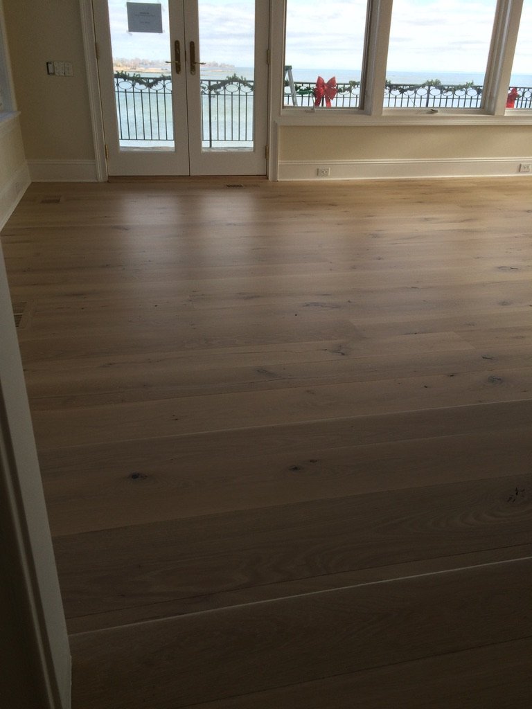 Wide-plank white oak hardwood floor in a Stamford, CT sunroom with a water-view seating area