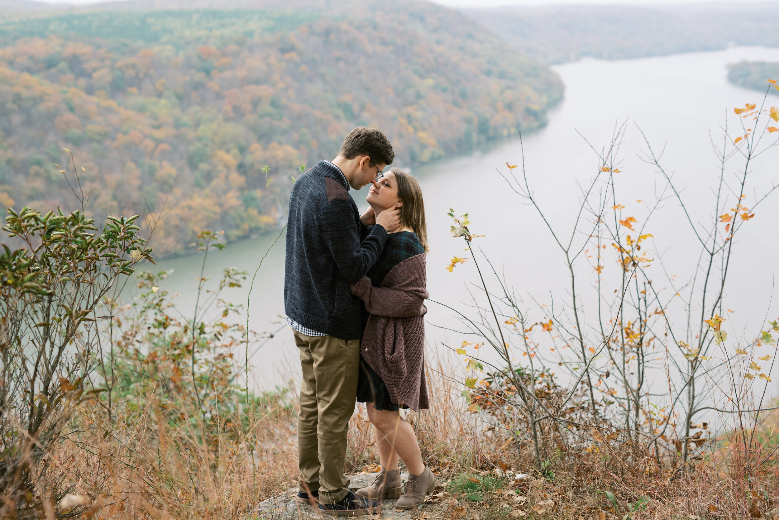 Couple gazing into each others eyes during an engagement shoot. Pinnacle overlook is in the background of the image.