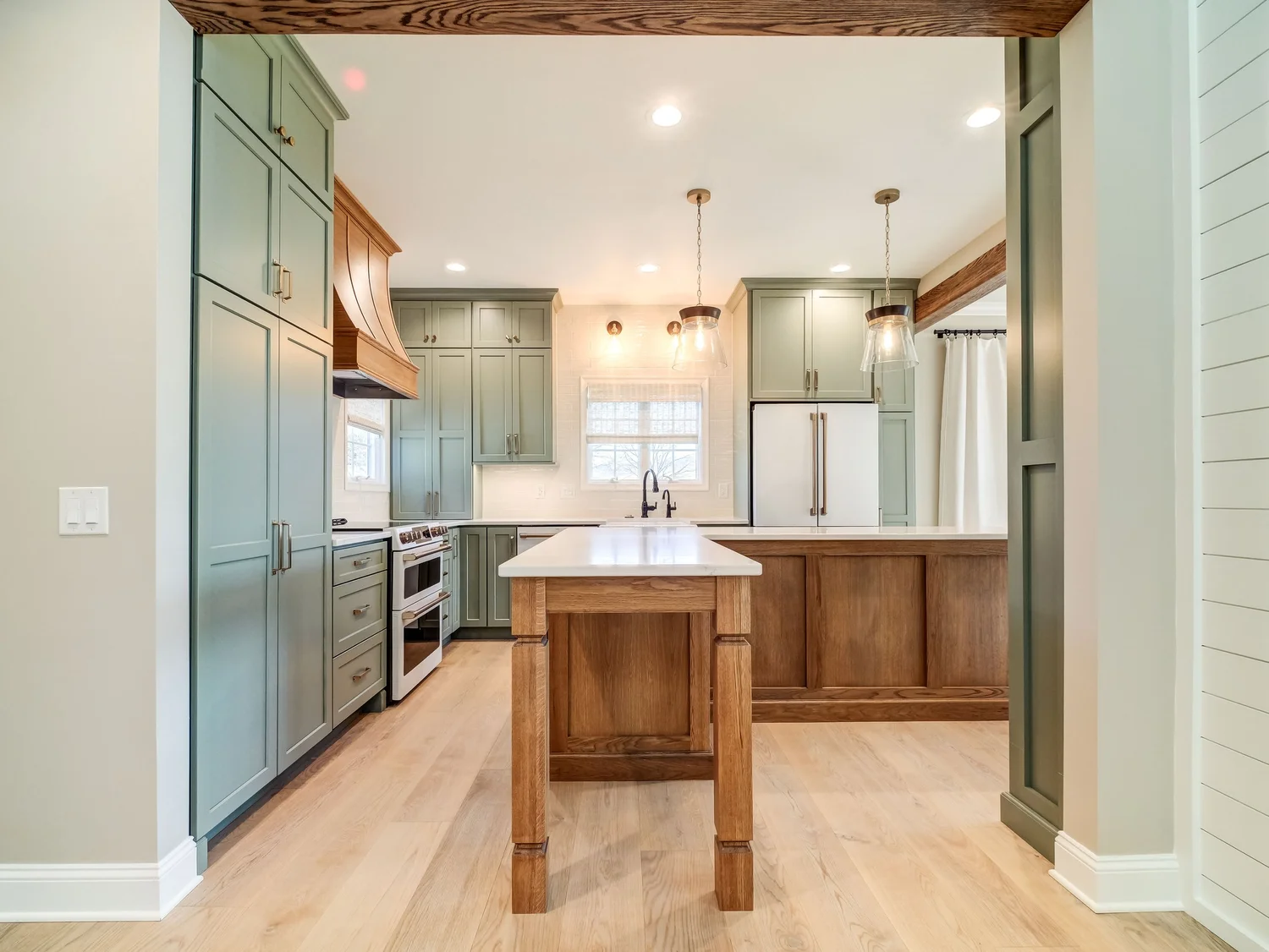 Water's Edge project kitchen with green perimeter cabinetry and a stained wood island, Smith Mountain Lake