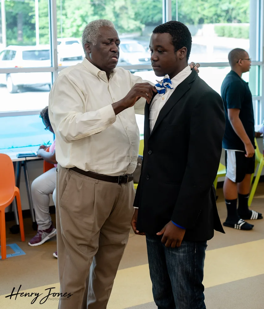 Brother Marion Wright helping Marcellus Charles Lewis with his bowtie.