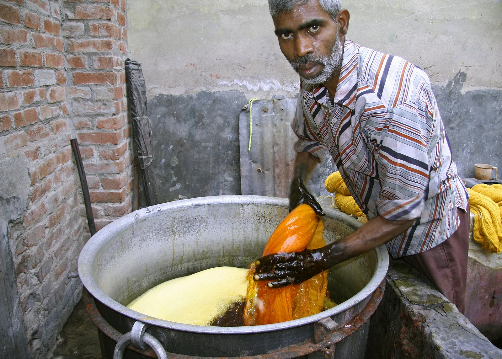 bigstock_man_dyeing_textile_in_india_25611782.jpg