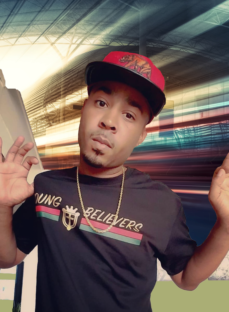 Young man wearing a black T-shirt with 'YOUNG BELIEVERS' written on it, a gold chain, and a red baseball cap with a lion logo, standing in a modern, brightly lit transportation hub or station with blurred streaks of lights in the background.