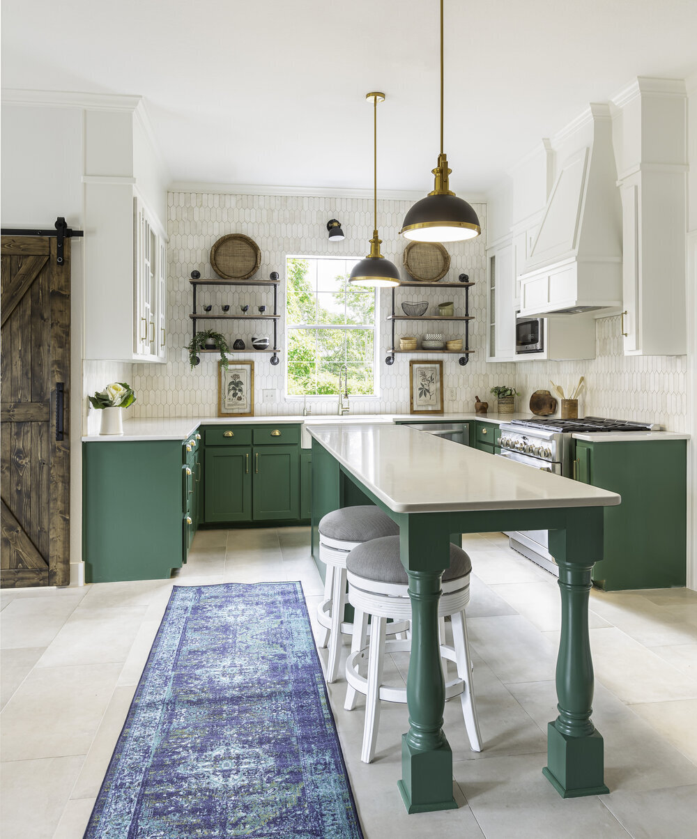 The Green English Country Kitchen with a Texas Twist by Ruthie Staalsen Interiors combines the traditional charm of an English country kitchen with the bold and vibrant elements of Texan design. The green color scheme adds a fresh and inviting feel to the space, while rustic wood accents and vintage details bring warmth and character to the room.