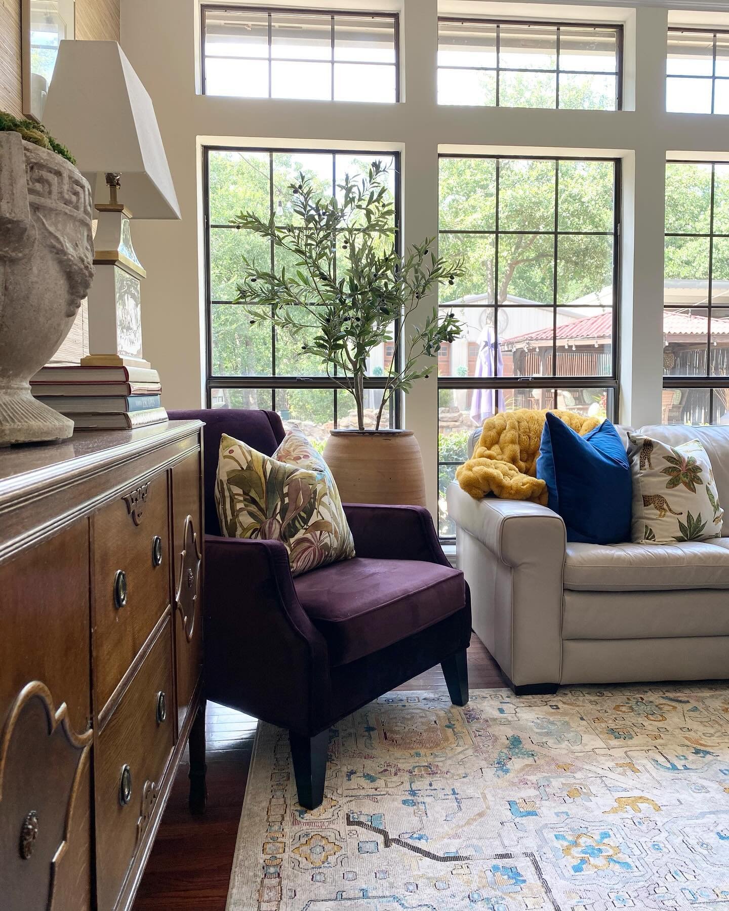 Who doesn&rsquo;t love natural light and colorful pillows paired with a vintage rug! #interiordesign #ruthiestaalseninteriors #leopardpillow #homedecor #livingspaces #olivetree #terracottapot #eggplantchairs #velvetchairs #dallasdesigner #colorfulhom